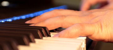 fotografie von händen, die auf einer klaviertastatur spielen