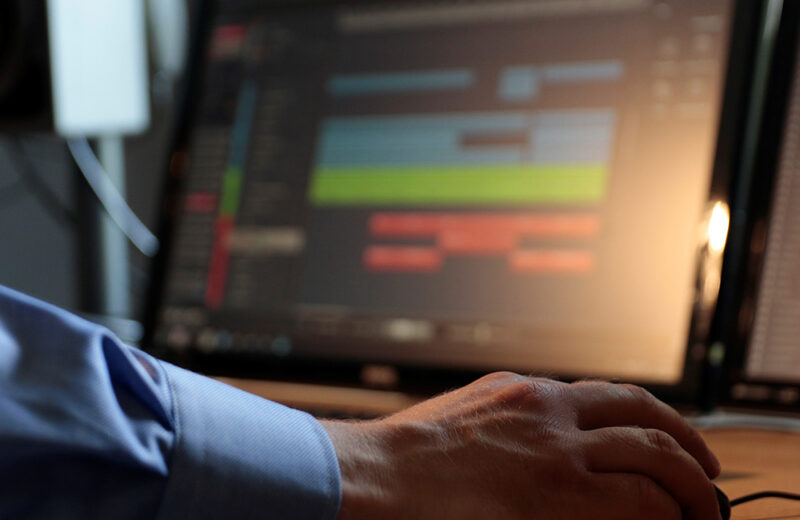 fotografie einer hand mit einer computermaus mit bildschirm im hintergrund